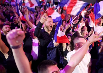 Supporters react as former president of the French far-right Rassemblement National (RN) parliamentary group Marine Le Pen gives a speech during the results of the first round of the parliamentary elections in Henin-Beaumont, northern France, on Sunday. Supporters react as former president of the French far-right Rassemblement National (RN) parliamentary group Marine Le Pen gives a speech during the results of the first round of the parliamentary elections in Henin-Beaumont, northern France, on Sunday.
