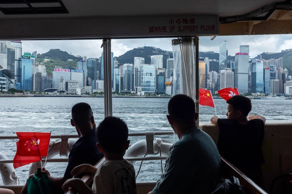 Attendees wave the flags of China and the Hong Kong Special Administrative Region during an event aboard a Star Ferry to celebrate the 27th anniversary of Hong Kong's return to Chinese rule in Hong Kong on July 1. Attendees wave the flags of China and the Hong Kong Special Administrative Region during an event aboard a Star Ferry to celebrate the 27th anniversary of Hong Kong's return to Chinese rule in Hong Kong on July 1.