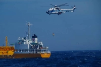 A woman is rescued by a helicopter on Wednesday off the coast of Chiba Prefecture after drifting at sea for 36 hours. | Courtesy of Yokosuka Coast Guard Office