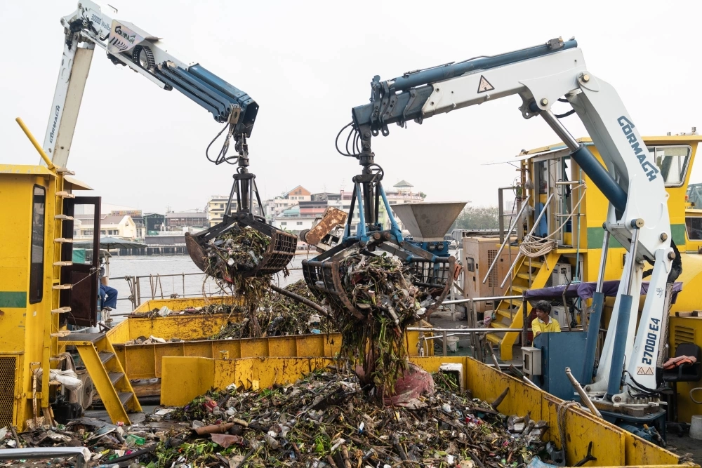 Heavy machinery collects waste from the Chao Phraya river in Bangkok. Heavy machinery collects waste from the Chao Phraya river in Bangkok.