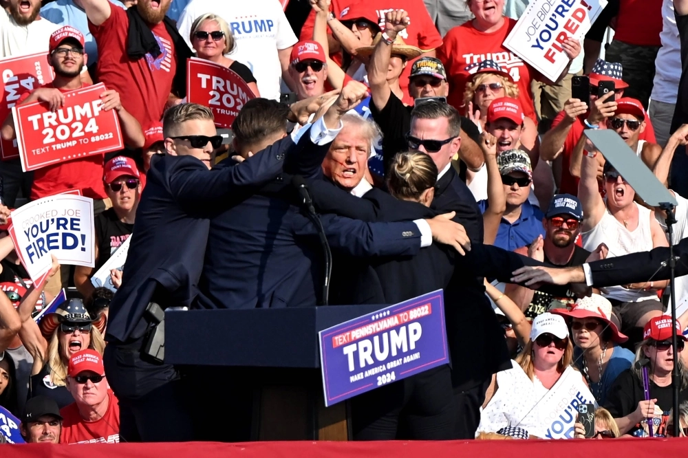 Secret Service agents surround former U.S. President Donald Trump after shots were fired during a campaign event in Butler, Pennsylvania, on Saturday. Secret Service agents surround former U.S. President Donald Trump after shots were fired during a campaign event in Butler, Pennsylvania, on Saturday.