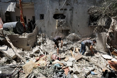 Palestinians search through rubble following an Israeli strike in Deir Al-Balah in the central Gaza Strip on Monday. Palestinians search through rubble following an Israeli strike in Deir Al-Balah in the central Gaza Strip on Monday.