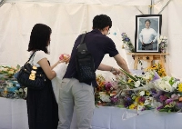 People lay flowers before the two year anniversary of the shooting of former Prime Minister Shinzo Abe in the city of Nara on July 7. | JIJI
