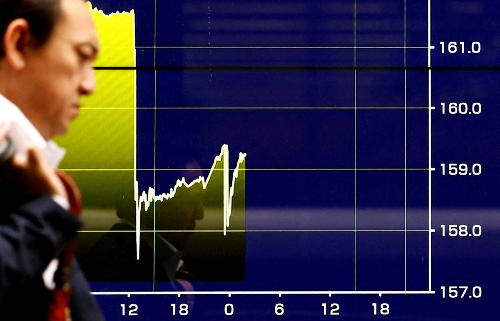 An electronic screen displays a graph showing yen exchange rates surging against the U.S. dollar amid an alert to the possibility of intervention in Tokyo on Friday. An electronic screen displays a graph showing yen exchange rates surging against the U.S. dollar amid an alert to the possibility of intervention in Tokyo on Friday.
