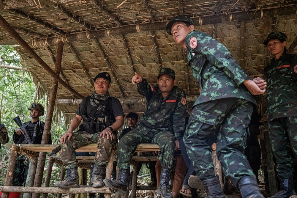 Ko Maung Saungkha, center, a poet who is a rebel commander in Myanmar, on the first day of training for new recruits in Karen State, on May 7.  Ko Maung Saungkha, center, a poet who is a rebel commander in Myanmar, on the first day of training for new recruits in Karen State, on May 7.