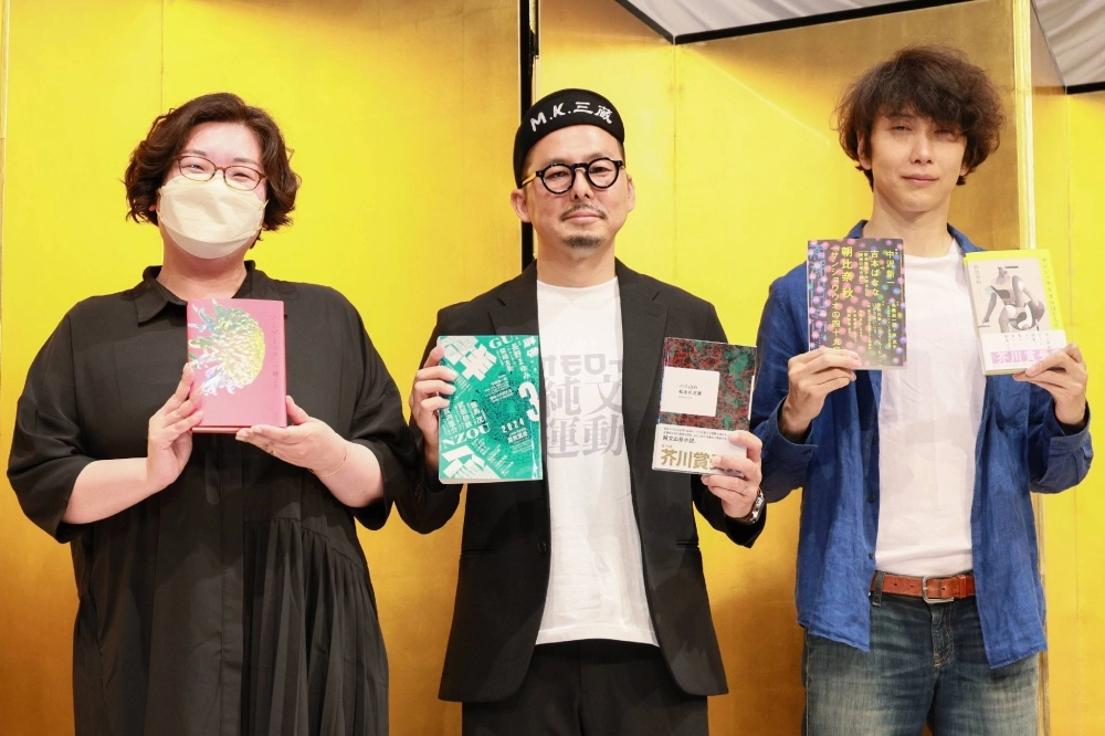 Naoki Prize winner Michi Ichiho (left), and Akutagawa Prize winners Sanzo K. Matsunaga (center) and Aki Asahina pose with their award-winning books at a news conference in Tokyo on Wednesday. Naoki Prize winner Michi Ichiho (left), and Akutagawa Prize winners Sanzo K. Matsunaga (center) and Aki Asahina pose with their award-winning books at a news conference in Tokyo on Wednesday.