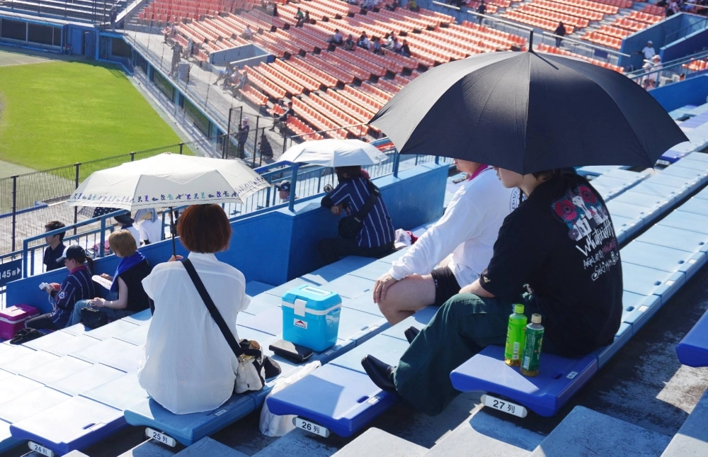 People hold umbrellas while watching baseball to deal with the heat in the city of Shizuoka on July 7. People hold umbrellas while watching baseball to deal with the heat in the city of Shizuoka on July 7.