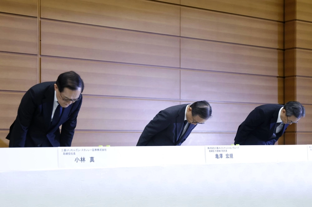 Mitsubishi UFJ Financial Group CEO Hironori Kamezawa (center) and other executives bow during a news conference in Tokyo on Friday. Mitsubishi UFJ Financial Group CEO Hironori Kamezawa (center) and other executives bow during a news conference in Tokyo on Friday.