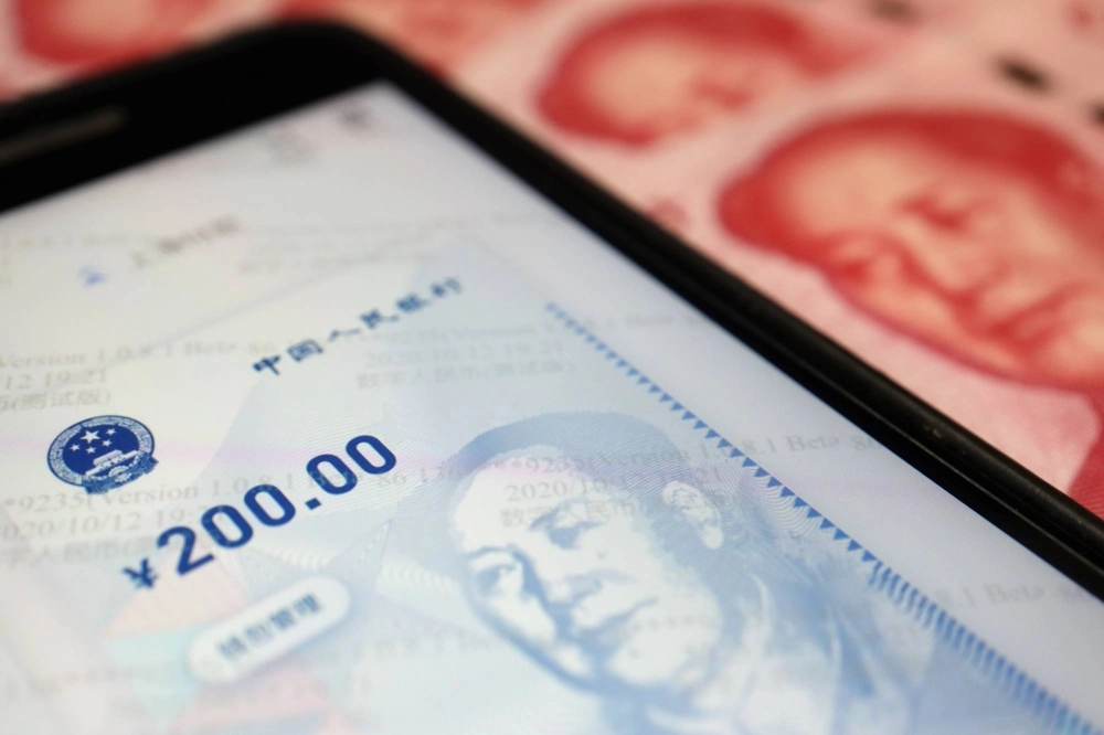 China's official app for digital yuan is seen on a mobile phone next to 100-yuan banknotes China's official app for digital yuan is seen on a mobile phone next to 100-yuan banknotes