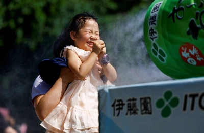 A child gets a break from the heat thanks to a cooling mist machine at Sensoji temple in Tokyo. A child gets a break from the heat thanks to a cooling mist machine at Sensoji temple in Tokyo.