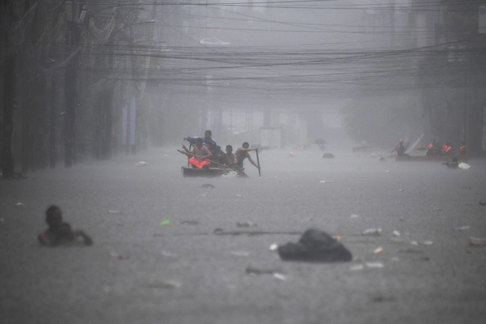 Rescuers paddle their boats along a flooded street in Manila on Wednesday amid heavy rains brought by Typhoon Gaemi. Rescuers paddle their boats along a flooded street in Manila on Wednesday amid heavy rains brought by Typhoon Gaemi.
