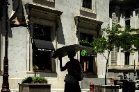 A pedestrian uses an umbrella for shade during high temperatures in Philadelphia. | Bloomberg