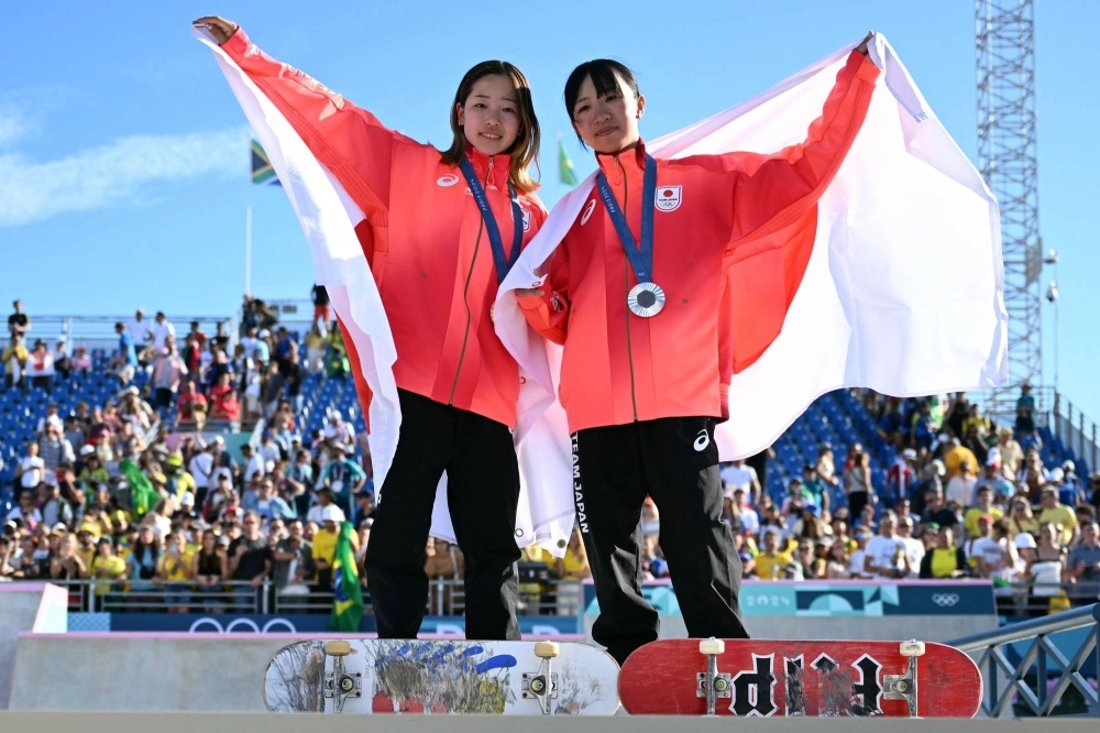 Gold medalist Coco Yoshizawa and silver medalist Liz Akama celebrate after the women's skateboarding street competition at La Concorde in Paris on Sunday. Gold medalist Coco Yoshizawa and silver medalist Liz Akama celebrate after the women's skateboarding street competition at La Concorde in Paris on Sunday.