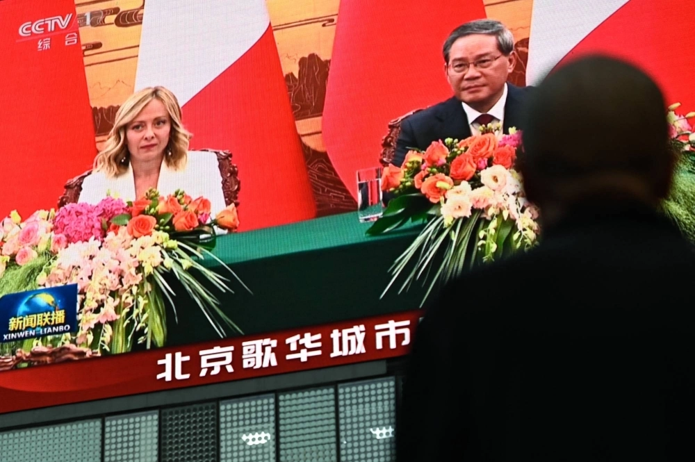 A screen shows news coverage of Italy's Prime Minister Giorgia Meloni meeting with China's Premier Li Qiang in Beijing on Sunday. A screen shows news coverage of Italy's Prime Minister Giorgia Meloni meeting with China's Premier Li Qiang in Beijing on Sunday.
