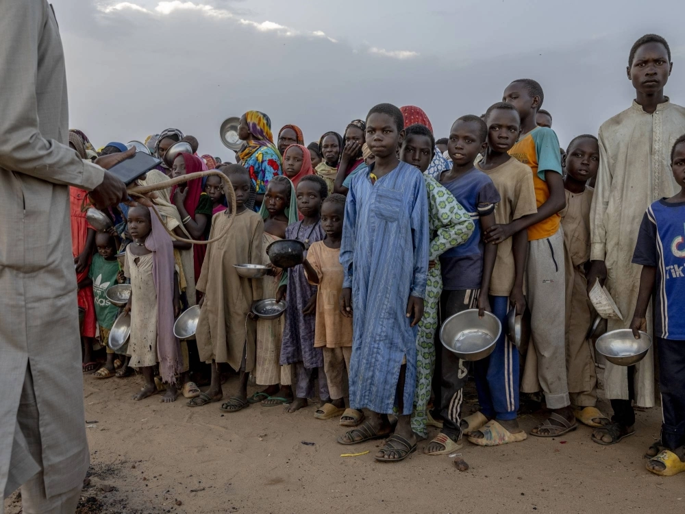 A man with a whip tries to control a crowd of Sudanese refugees waiting to receive food at an impromptu aid distribution on the outskirts of a refugee camp in Adre, Chad, on July 8. As starvation spreads in Sudan, its military is blocking the United Nations from bringing food into the country via the most straightforward route. A man with a whip tries to control a crowd of Sudanese refugees waiting to receive food at an impromptu aid distribution on the outskirts of a refugee camp in Adre, Chad, on July 8. As starvation spreads in Sudan, its military is blocking the United Nations from bringing food into the country via the most straightforward route.
