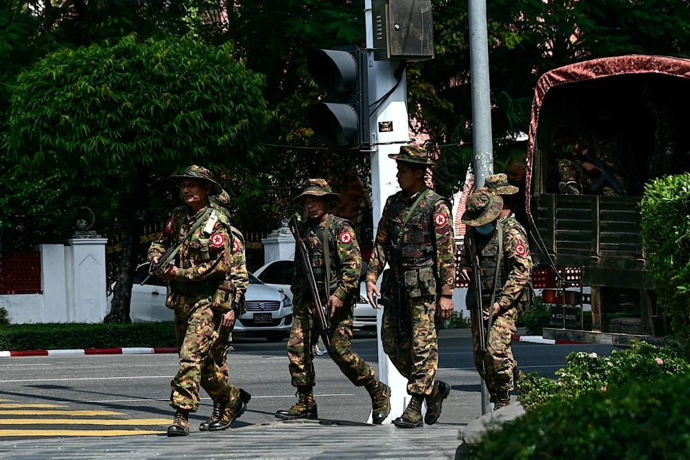 Members of Myanmar's military security force patrol a street in Yangon, Myanmar. Members of Myanmar's military security force patrol a street in Yangon, Myanmar.
