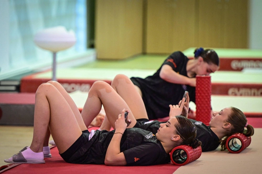 Members of the Romanian Olympic women's gymnastics team check their smartphones during a training session early last month. Members of the Romanian Olympic women's gymnastics team check their smartphones during a training session early last month.