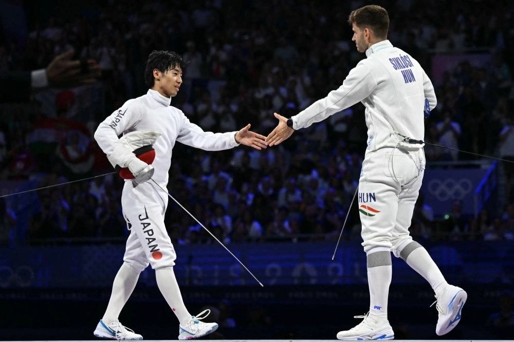 Japan's Koki Kano shakes hands with Hungary's Gergely Siklosi at the end of the men's epee team gold medal bout between Japan and Hungary during the Paris 2024 Olympic Games at the Grand Palais in Paris on Friday. Japan's Koki Kano shakes hands with Hungary's Gergely Siklosi at the end of the men's epee team gold medal bout between Japan and Hungary during the Paris 2024 Olympic Games at the Grand Palais in Paris on Friday.