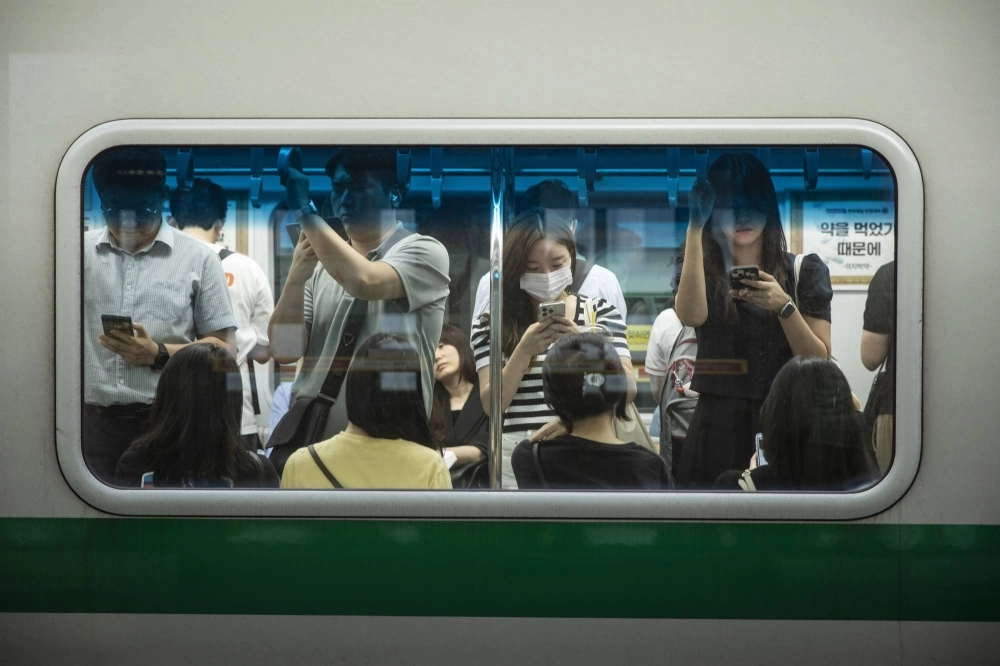 Commuters take a subway home at Sungsu station in Seoul on July 15.  Commuters take a subway home at Sungsu station in Seoul on July 15.