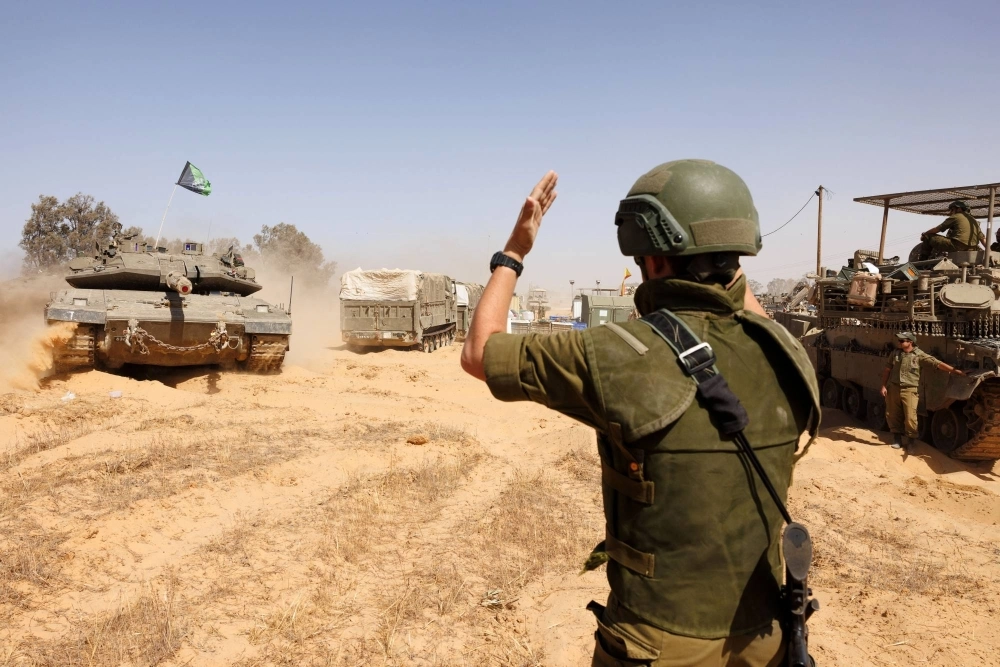 A soldier directs Israeli tanks near a border crossing to southern Gaza. A soldier directs Israeli tanks near a border crossing to southern Gaza.