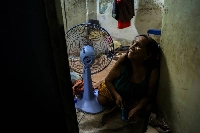 A woman uses a fan to cool down in Bangkok on April 28. | REUTERS