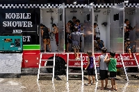 Children use a mobile shower, provided by the local government, amid extreme heat in metro Manila on May 2. | REUTERS