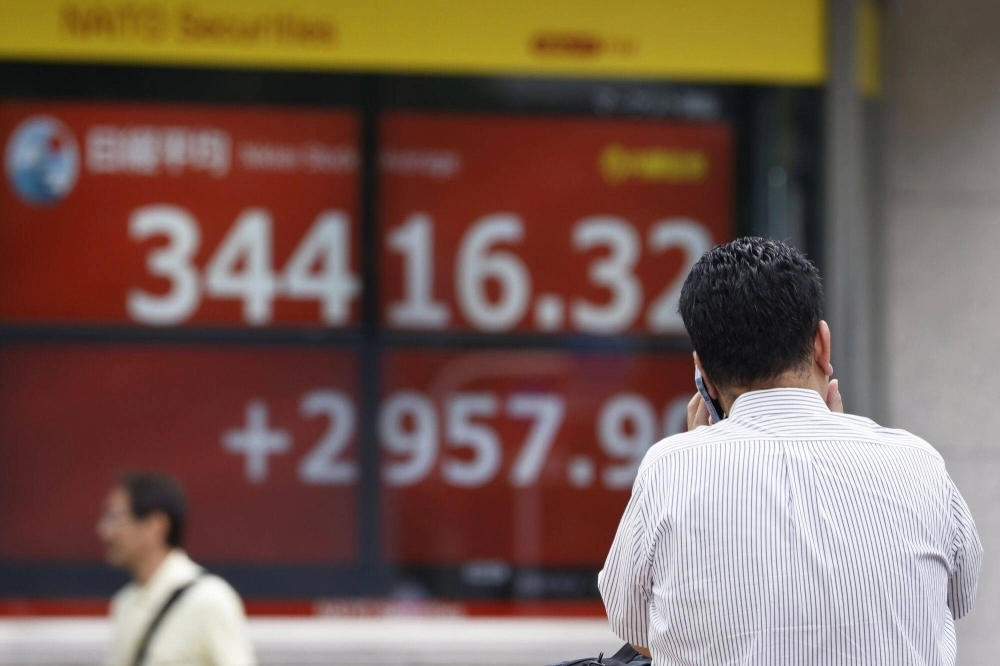 An electronic stock board displaying the Nikkei 225-issue Nikkei average outside a securities firm in Tokyo on Tuesday. An electronic stock board displaying the Nikkei 225-issue Nikkei average outside a securities firm in Tokyo on Tuesday.