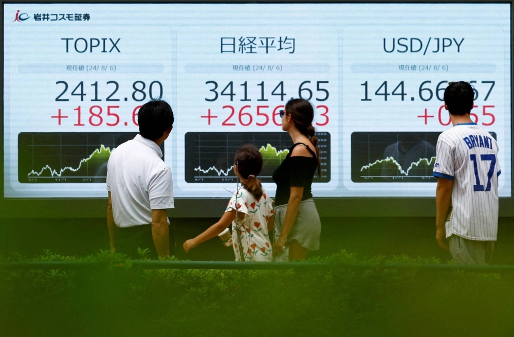 An electronic board displaying Topix and the yen exchange rate against the U.S. dollar outside a brokerage in Tokyo on Tuesday. An electronic board displaying Topix and the yen exchange rate against the U.S. dollar outside a brokerage in Tokyo on Tuesday.