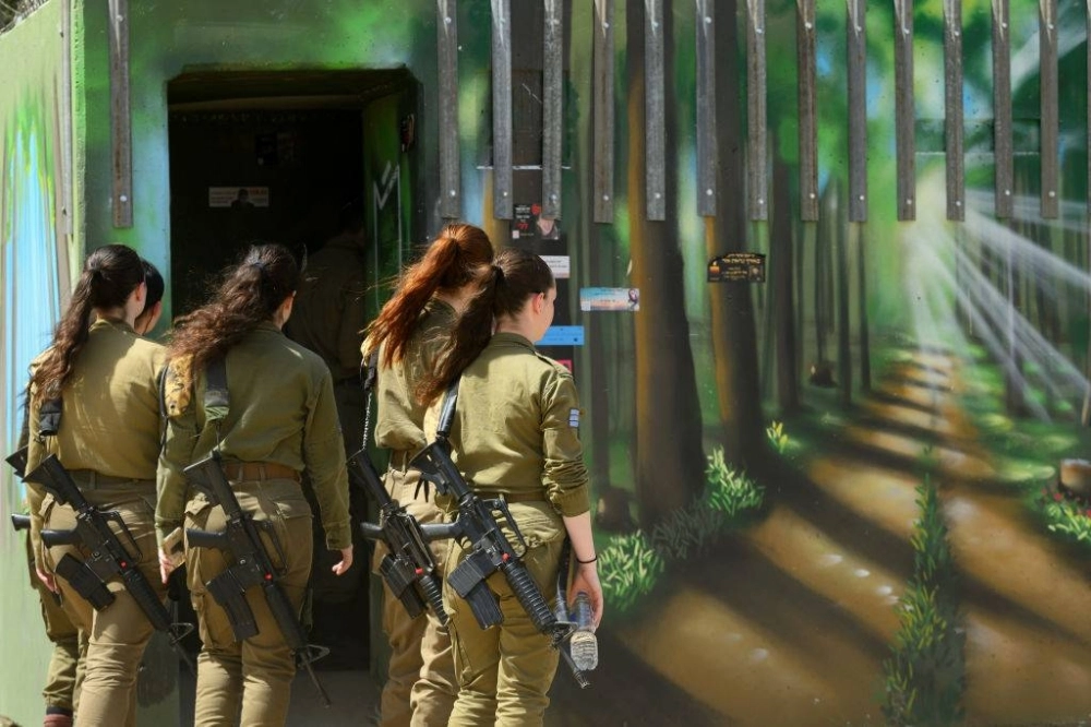 Soldiers look at a bomb shelter painted like a forest at the Nova memorial site in Re’im, Israel, in April. Soldiers look at a bomb shelter painted like a forest at the Nova memorial site in Re’im, Israel, in April.