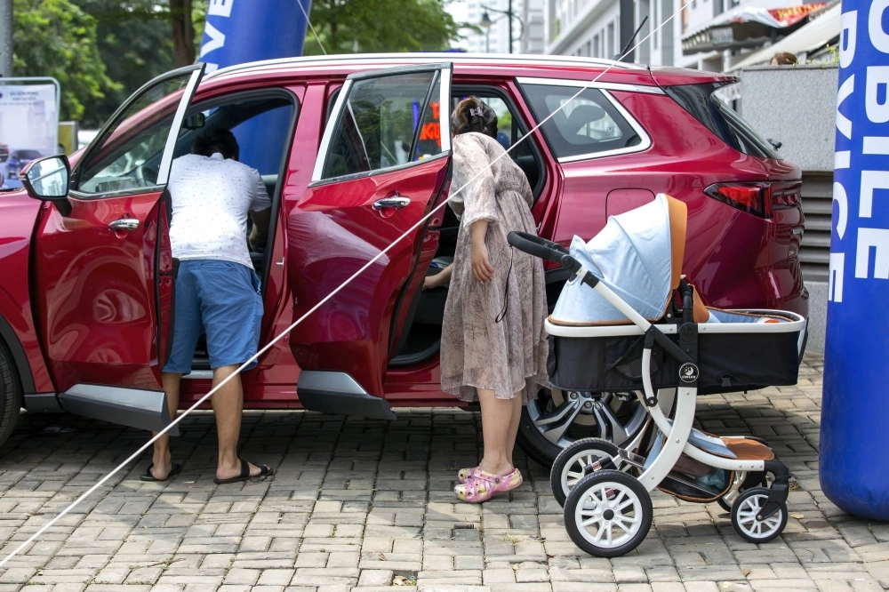 People look at a Ford Sports Utility Vehicle on display at a test drive point in Nha Be district in Ho Chi Minh City. People look at a Ford Sports Utility Vehicle on display at a test drive point in Nha Be district in Ho Chi Minh City.