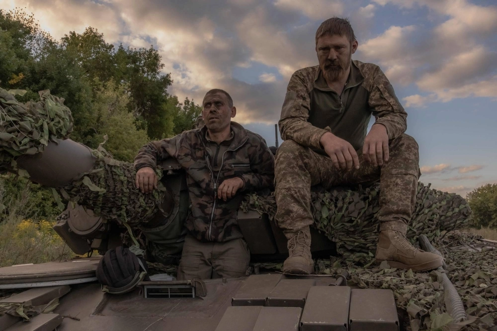A Ukrainian tank crew take a break while operating a Soviet-made T-72 tank in the Sumy region, near the border with Russia, on Aug. 12. A Ukrainian tank crew take a break while operating a Soviet-made T-72 tank in the Sumy region, near the border with Russia, on Aug. 12.