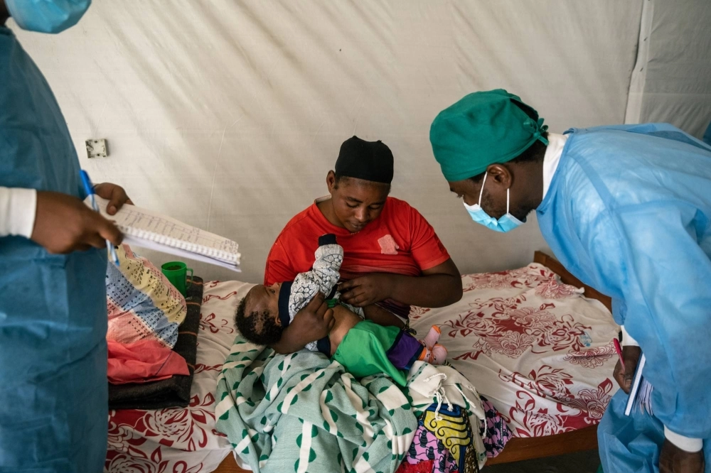 A woman shows a health worker the mpox lesions on her child at the Munigi mpox treatment center in Nyiragongo territory, North Kivu, Democratic Republic of Congo. A woman shows a health worker the mpox lesions on her child at the Munigi mpox treatment center in Nyiragongo territory, North Kivu, Democratic Republic of Congo.