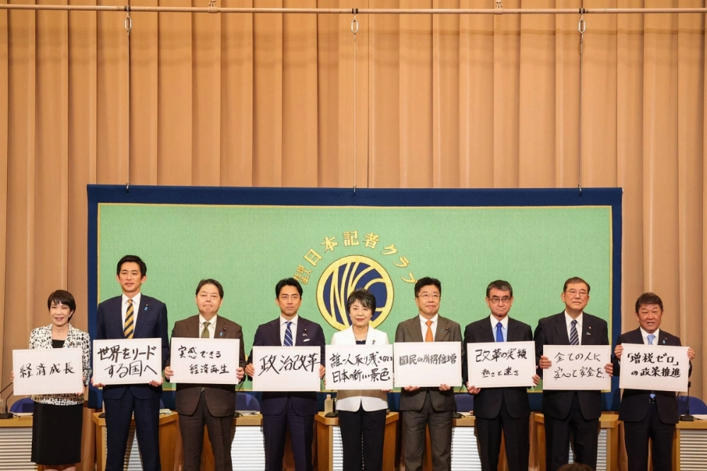 Candidates for Japan's ruling Liberal Democratic Party presidential election stand together onstage at the Japan National Press Club in Tokyo on Saturday. Candidates for Japan's ruling Liberal Democratic Party presidential election stand together onstage at the Japan National Press Club in Tokyo on Saturday.