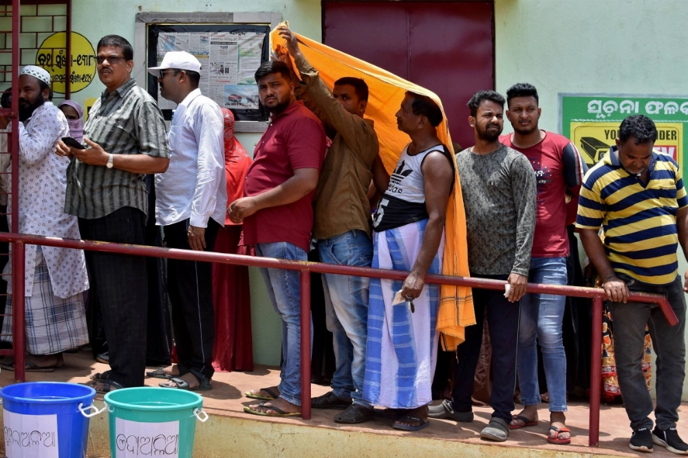 Men use a stole to cover themselves from the sun as they wait in a line outside a polling station to cast their votes during the sixth phase of India's general election in Bhubaneswar, India, on May 25. Men use a stole to cover themselves from the sun as they wait in a line outside a polling station to cast their votes during the sixth phase of India's general election in Bhubaneswar, India, on May 25.