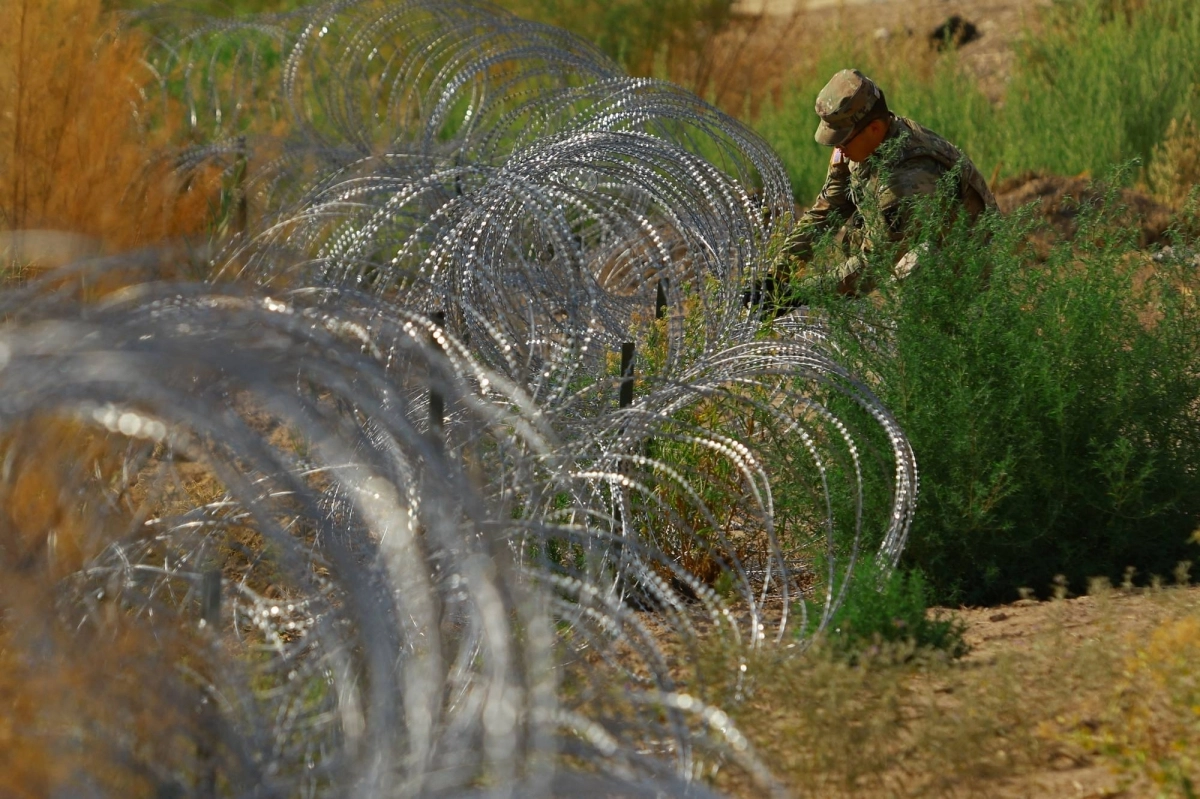 A member of the Texas National Guard places razor wire near the American border with Mexico, in El Paso, Texas, on Aug. 7.  A member of the Texas National Guard places razor wire near the American border with Mexico, in El Paso, Texas, on Aug. 7.