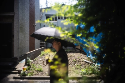 A woman passes an "akichi" (vacant lot) in Bunkyo Ward, Tokyo. The capital is littered with such small lots in part because of Japan's aging and shrinking population. A woman passes an "akichi" (vacant lot) in Bunkyo Ward, Tokyo. The capital is littered with such small lots in part because of Japan's aging and shrinking population.