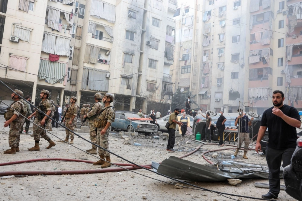 Lebanese soldiers and civilians inspect the site of an Israeli strike in the southern suburbs of Beirut on Friday. Lebanese soldiers and civilians inspect the site of an Israeli strike in the southern suburbs of Beirut on Friday.