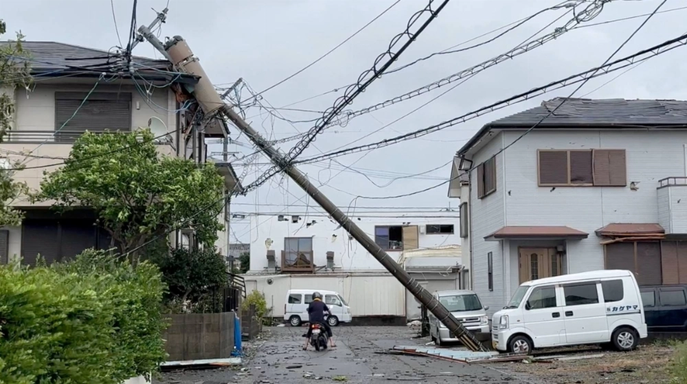 A person rides a scooter underneath a fallen pole following Typhoon Shanshan in Miyazaki on Aug. 29 in this screengrab taken from a social media video. A person rides a scooter underneath a fallen pole following Typhoon Shanshan in Miyazaki on Aug. 29 in this screengrab taken from a social media video.