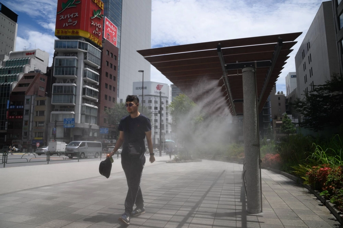 A pedestrian walks next to a cooling mist spray in the Ginza district of Tokyo on July 19. A pedestrian walks next to a cooling mist spray in the Ginza district of Tokyo on July 19.