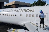 A worker cleans a Garuda Indonesia aircraft parked at Soekarno-Hatta International Airport near Jakarta in 2022. Garuda said it’s operating user-preferred routing on flights from Jakarta to Sydney and Melbourne. | REUTERS