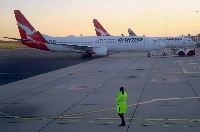 Workers are seen near Qantas Airways' Boeing 737-800 aircraft on the tarmac of Adelaide Airport, Australia, in 2018. Qantas is one of four airlines involved in the trial. | REUTERS