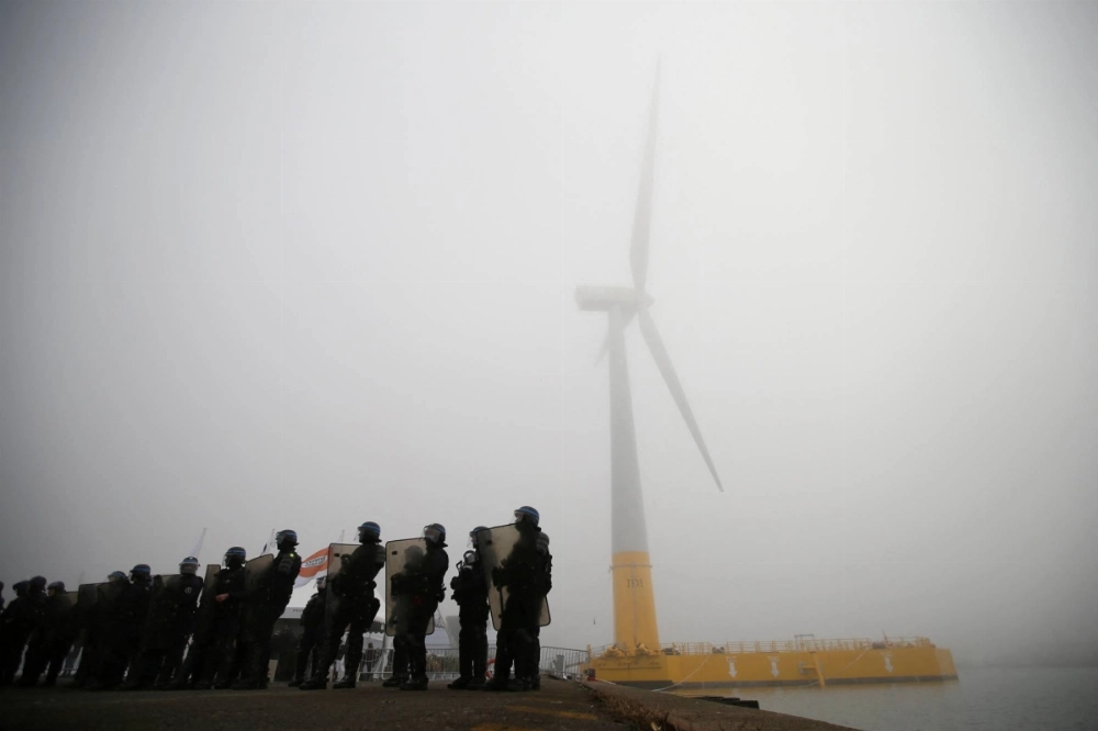French riot police take position as part of a demonstration by dockers during the inauguration of the first French offshore floating wind turbine, Floatgen, in the port of Saint-Nazaire, France, in 2017.  French riot police take position as part of a demonstration by dockers during the inauguration of the first French offshore floating wind turbine, Floatgen, in the port of Saint-Nazaire, France, in 2017.