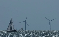 A yacht sails in front of an offshore wind farm, seen from Walton-on-the-Naze, southern Britain, on Aug. 13. | REUTERS