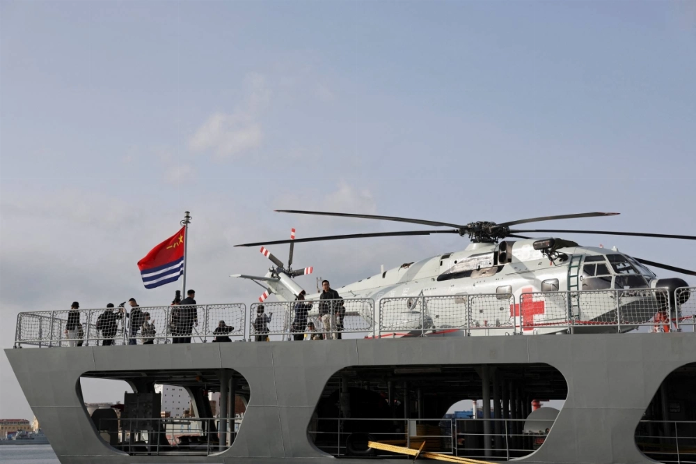 Visitors stand near a transport helicopter during a public viewing by the Chinese People's Liberation Army Navy to mark its upcoming 75th founding anniversary, at the port in Qingdao, China, on April 20. Visitors stand near a transport helicopter during a public viewing by the Chinese People's Liberation Army Navy to mark its upcoming 75th founding anniversary, at the port in Qingdao, China, on April 20.
