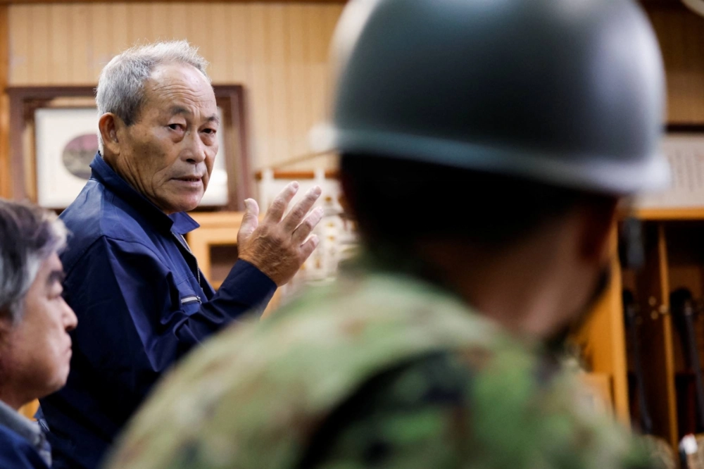 Yonaguni Mayor Kenichi Itokazu speaks to a Ground Self-Defense Force soldier at the town hall on Yonaguni, Japan's westernmost inhabited island in Okinawa Prefecture last  November. Yonaguni Mayor Kenichi Itokazu speaks to a Ground Self-Defense Force soldier at the town hall on Yonaguni, Japan's westernmost inhabited island in Okinawa Prefecture last  November.