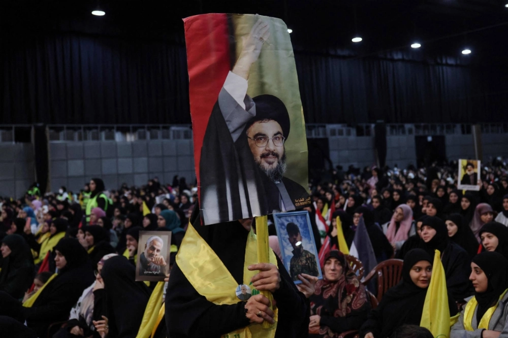 A supporter holds a portrait of Hezbollah chief Hassan Nasrallah during an event in a southern suburb of Beirut on Jan. 3.  A supporter holds a portrait of Hezbollah chief Hassan Nasrallah during an event in a southern suburb of Beirut on Jan. 3.