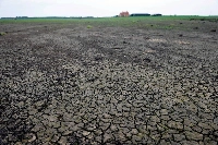 Cracked ground at a farm in Lincoln, U.K. Extreme weather worldwide is pushing up prices for food staples in ways that could eventually flow through to higher grocery bills. | Bloomberg