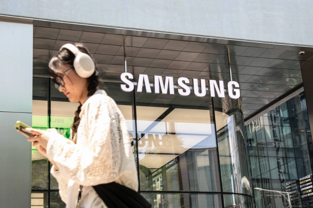 A woman walks past a Samsung store in Seoul on June 28. Sources have said that the firm is planning overseas layoffs. A woman walks past a Samsung store in Seoul on June 28. Sources have said that the firm is planning overseas layoffs.
