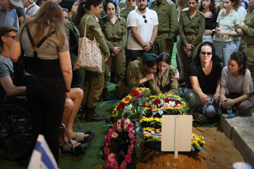 Relatives and friends mourn by the grave of Israeli soldier Eitan Itzhak Oster, killed in fighting in the northern border area with Lebanon, at the Mount Herzl Military Cemetery in Jerusalem on Oct. 2. Relatives and friends mourn by the grave of Israeli soldier Eitan Itzhak Oster, killed in fighting in the northern border area with Lebanon, at the Mount Herzl Military Cemetery in Jerusalem on Oct. 2.