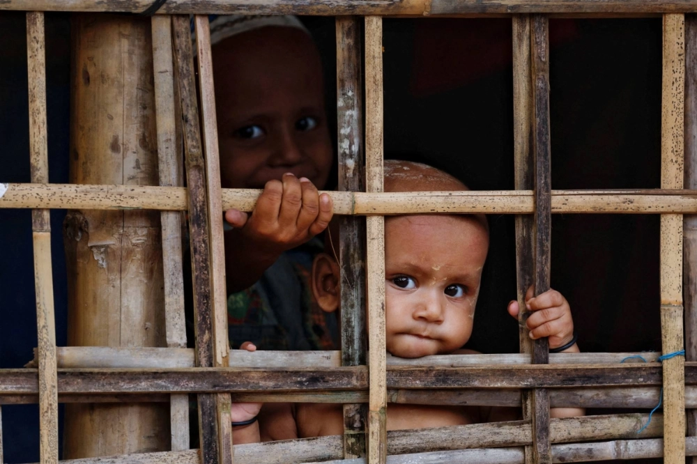 Rohingya refugee children look on from their shelter at a refugee camp, in Cox's Bazar, Bangladesh, on Sept. 28. Rohingya refugee children look on from their shelter at a refugee camp, in Cox's Bazar, Bangladesh, on Sept. 28.